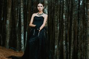 Beautiful woman with make-up, in black dress, wearing necklace