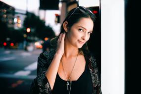 Portrait of the smiling, posing girl with glasses, on the street with colorful lights