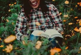 girl reading a book in wildflowers