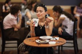 beautiful Woman eating at table in cafe