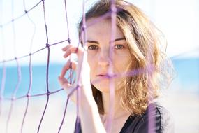photo of a girl holding a volleyball net