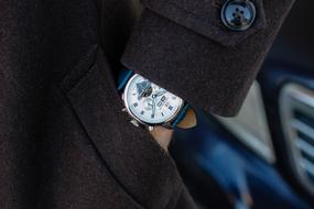watch on a man's hand in a coat