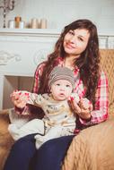 Family love, happy young mother with baby son sitting on armchair