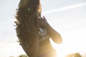 Beautiful, blonde girl, in the black and white "Adidas" top, in sunlight