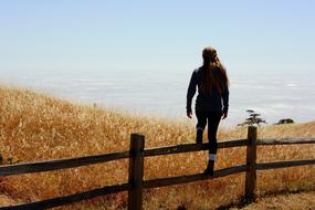 girl standing on fence