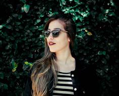 Beautiful girl with make-up, wearing sunglasses, near the green plants
