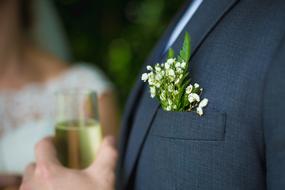 groom with a glass of champagne on a blurred background