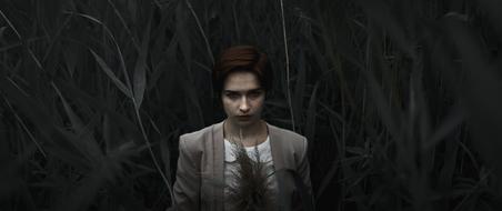 woman in tall grass in the dark