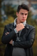 young man in black leather jacket on blurred background