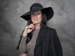 adult woman in a big black hat on a photo shoot