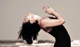 yoga, woman arching her back on the beach