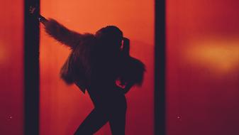 Silhouette of a posing woman on the stage, in beautiful, red, orange and yellow light