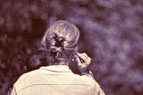 Photo with back view of the woman near the plants, with sepia effect