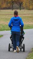 woman with baby carriage in autumn park