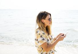 young Girl with smartphone at sea