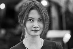 Black and white photo, with the portrait of the beautiful woman, in Cambodia, at background with the bokeh lights