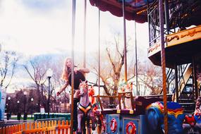 young Girl on carousel in amusement park, russia, moscow