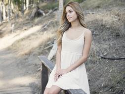 Beautiful Smiling Girl sits on bench