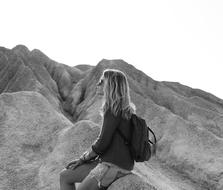 woman with backpack resting in the mountains in black and white background