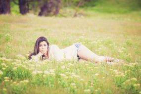 beautiful girl posing on a flower meadow
