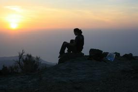 silhouette of a woman on top of a mountain at sunrise