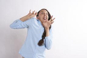 Scared woman with the open hands, at white background, in light