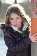 Portrait of the cute child girl, in light, on the snow, in the winter