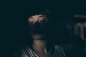 girl with closed eyes in deep shadow