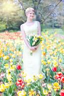 photo of a girl in a white dress on a blooming field of tulips