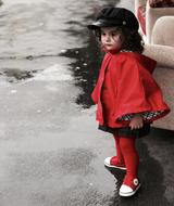 little girl in a red coat on the street