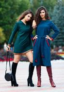 Beautiful women, on the shoes, with the bag, posing, near the colorful trees in the park