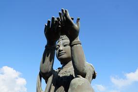 sculpture with hands to the sky