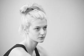 Black and white with the portrait of the beautiful girl with blonde hair, in black clothing