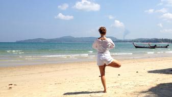 girl holds balance on a tropical beach