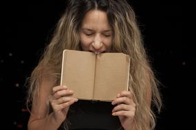 Young Woman biting open book
