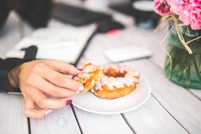 Doughnut in female hand at table