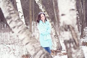 photo of Pretty young Girl among birch trees at winter