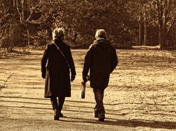 black and white photo of an elderly couple walking in the park