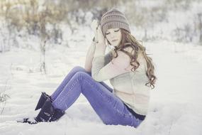 girl with closed eyes sitting in the snow