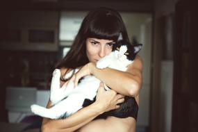 Girl, holding beautiful and cute, white and black cat, in the hands