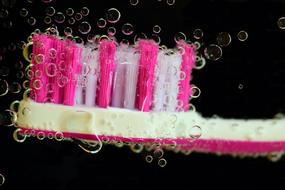White and pink toothbrush in bubbles