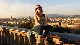 photo of a girl sitting on the waterfront in Florence, Italy