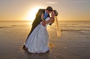 newlyweds kiss on the evening beach