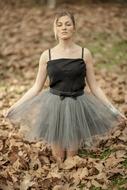young Girl kneeling on fallen leaves