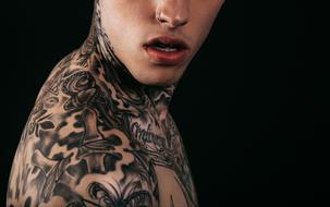 profile portrait of a young man with tattoos