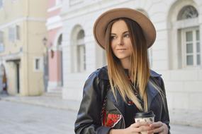 photo of blonde with a glass of coffee in the city center