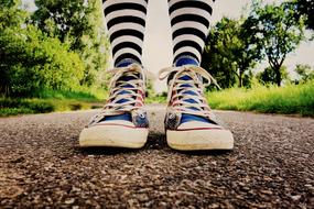female Feet in sneakers on path