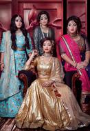 four young asian women in luxury dresses posing indoor
