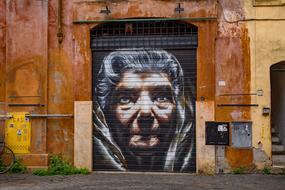 graffiti in the form of a woman's face on the wall in rome