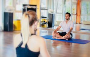 girl and young man meditate in gym in studio